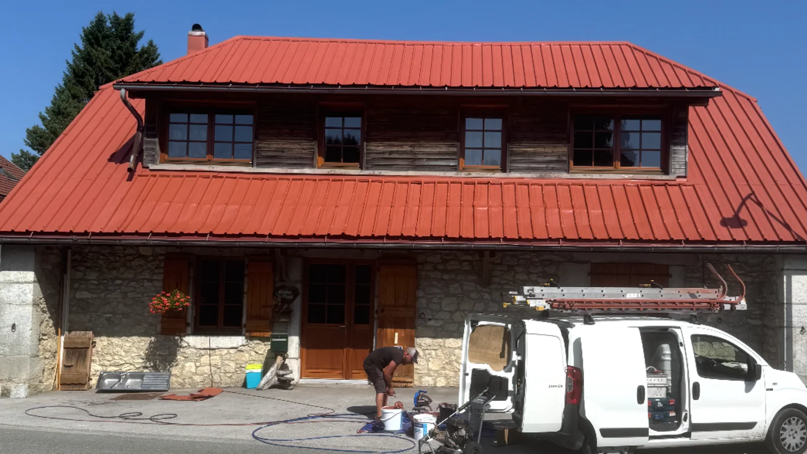 La même maison pendant le chantier, toit repeint d'un rouge uniforme.